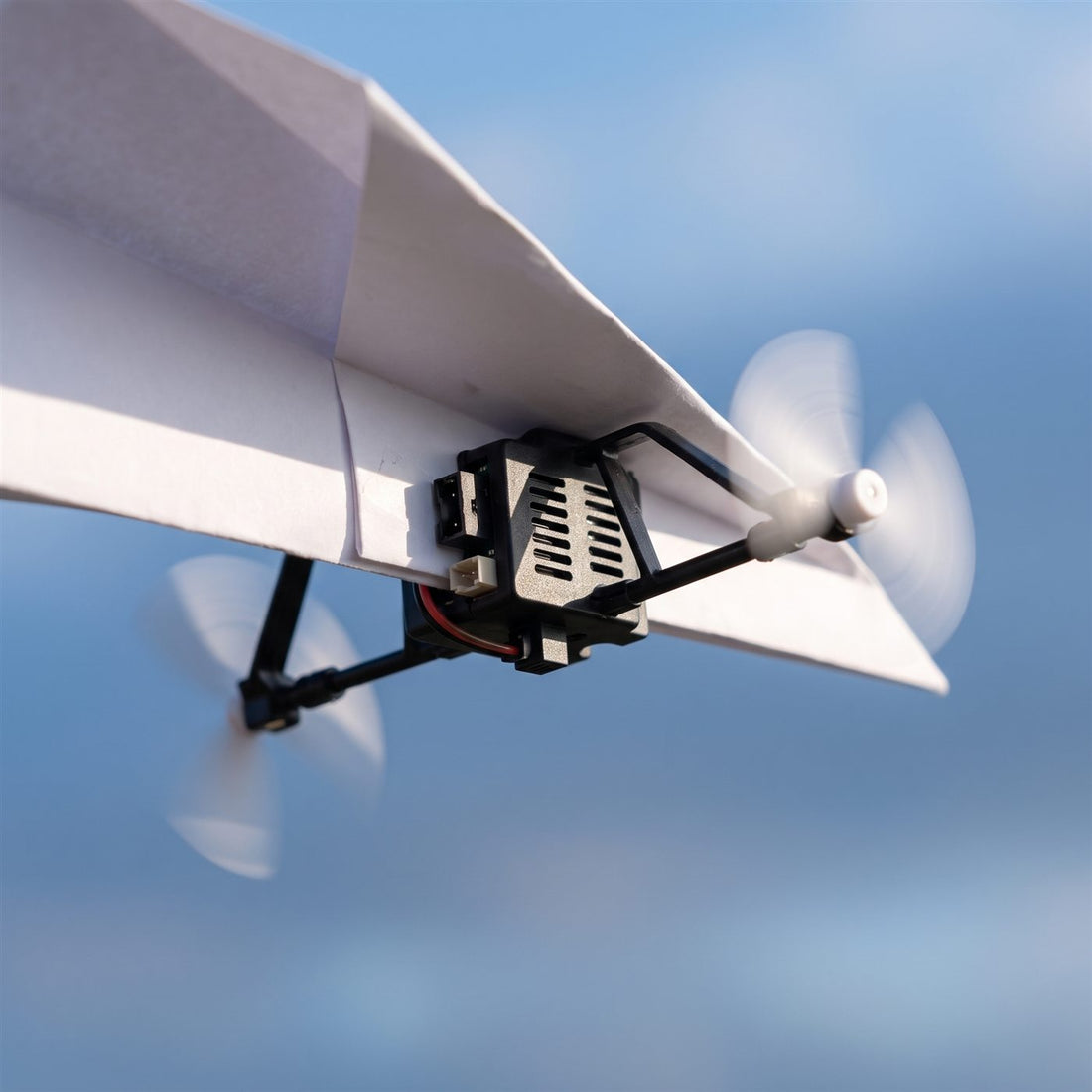 Module à double hélice et gyroscope sous un avion en papier